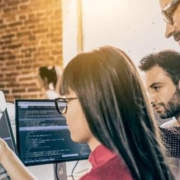 Businesspeople talking and pointing to computer in office