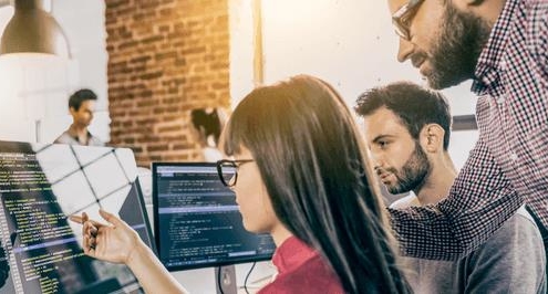 Businesspeople talking and pointing to computer in office