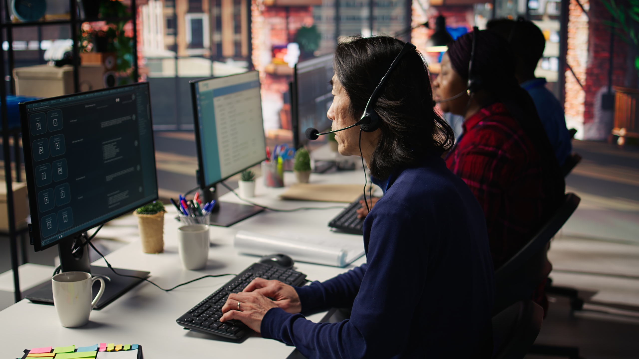 IT support agents wearing headsets at computer workstations