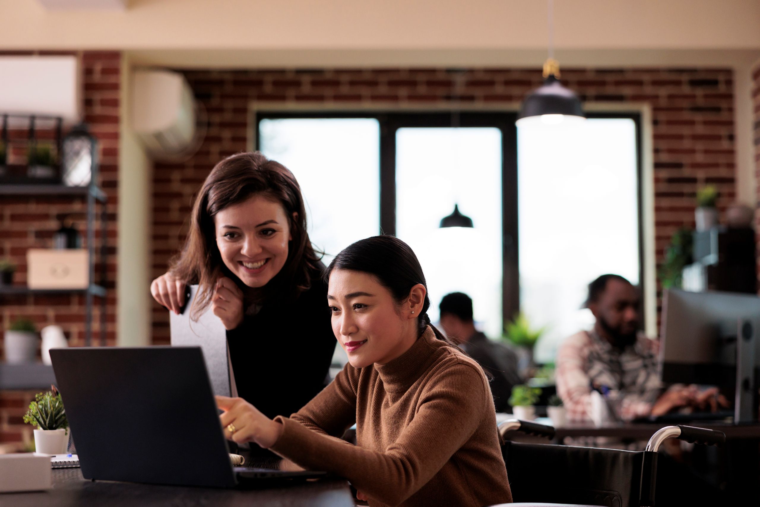 IT professionals smiling and pointing at laptop. IT professionals smiling and pointing at laptop.